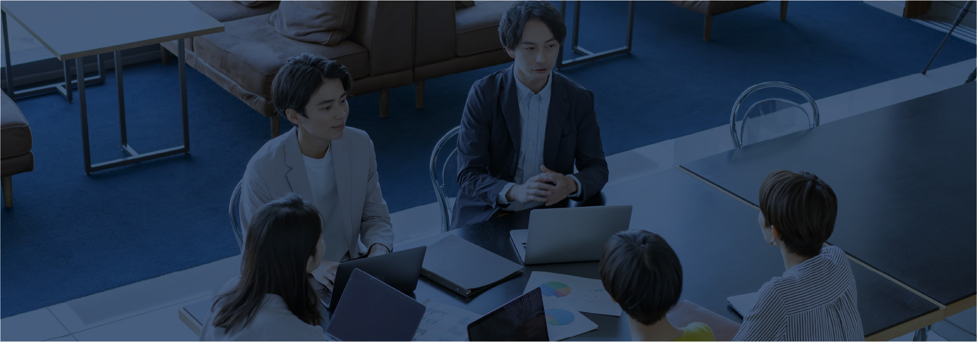 会議中のグループがテーブルを囲んで話し合う様子